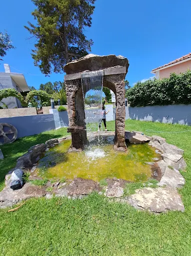 Fonte de pedra em arco com cascata no jardim principal
